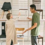 woman choosing between stylish clothes and book